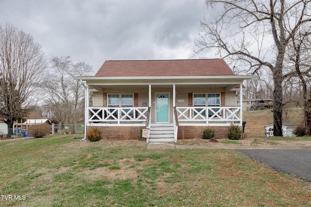 bungalow featuring covered porch and a front lawn