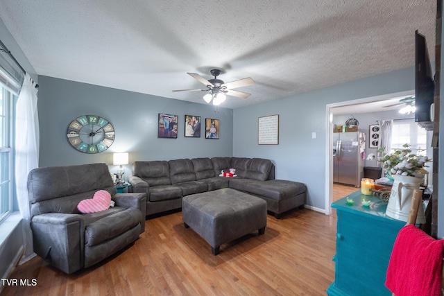 living room featuring a textured ceiling, a ceiling fan, and wood finished floors