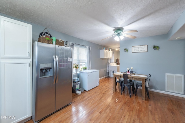 dining room with washer / clothes dryer, visible vents, a ceiling fan, a textured ceiling, and light wood-type flooring