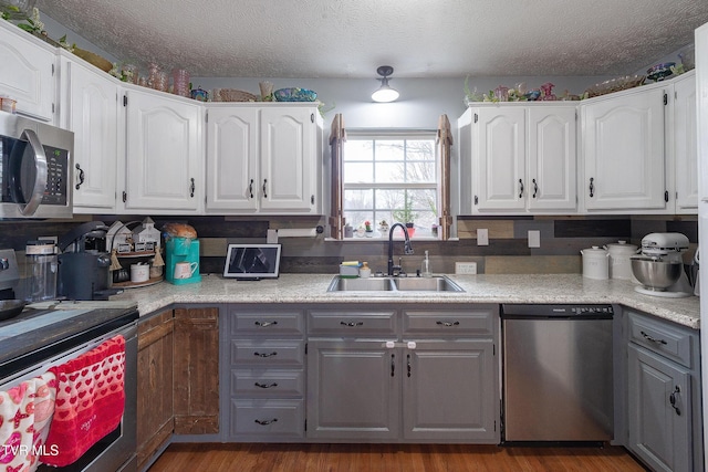 kitchen featuring white cabinetry, appliances with stainless steel finishes, and a sink