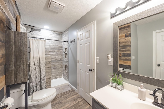 full bathroom with a stall shower, visible vents, a textured ceiling, and toilet