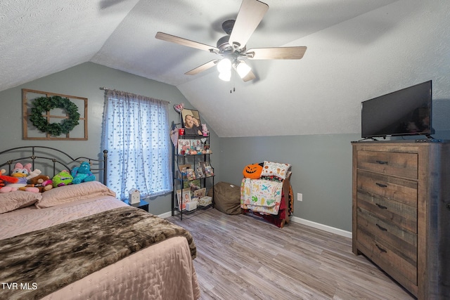 bedroom featuring a textured ceiling, light wood finished floors, lofted ceiling, and baseboards