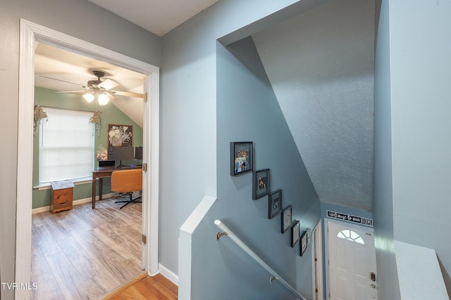 stairway with a ceiling fan, baseboards, and wood finished floors