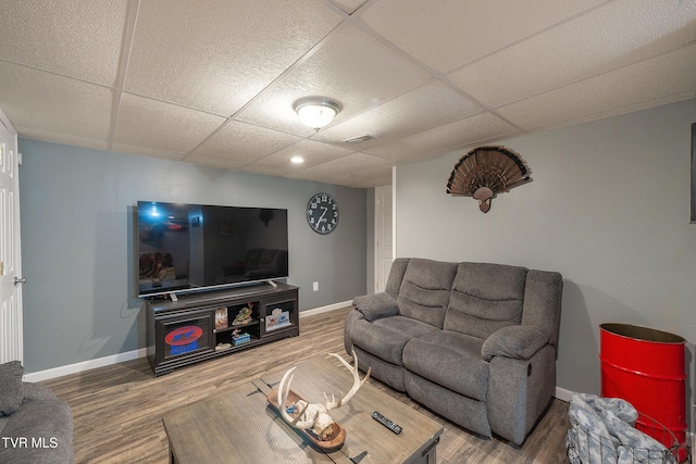 living room featuring a drop ceiling, wood finished floors, and visible vents