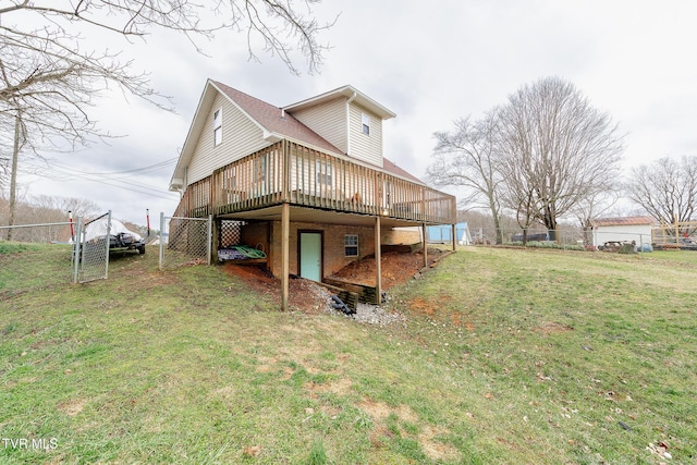 back of property featuring fence, a lawn, and a wooden deck