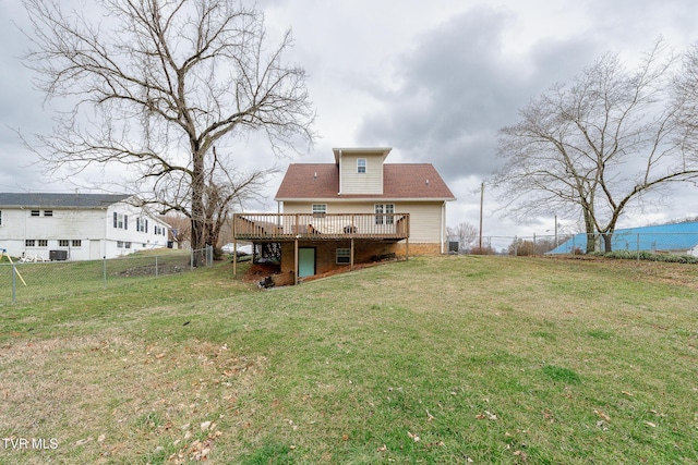 rear view of house featuring a deck, a yard, and a fenced backyard