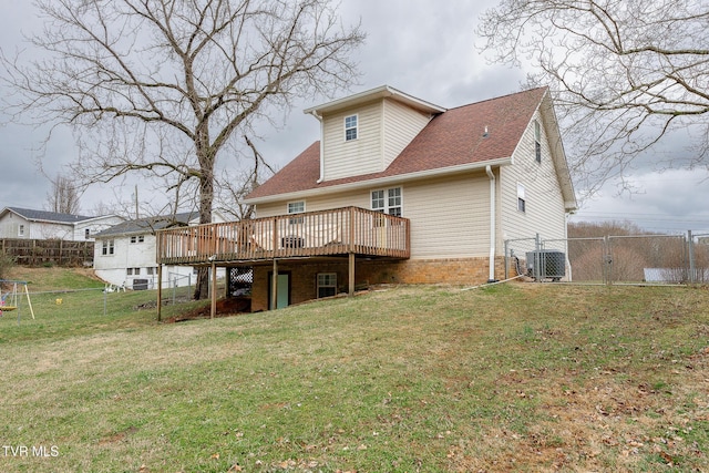 rear view of property with a yard, a deck, and fence