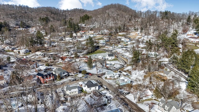 snowy aerial view with a residential view and a mountain view