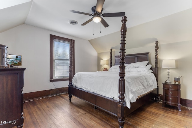 bedroom with lofted ceiling, visible vents, and dark wood finished floors