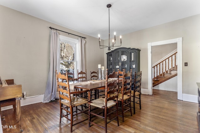 dining room featuring a chandelier, dark wood-type flooring, stairway, and baseboards