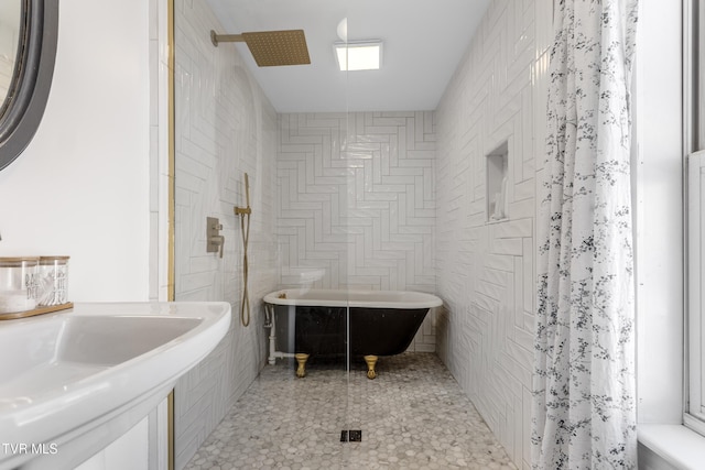 full bathroom with a freestanding bath, a shower, and tile walls