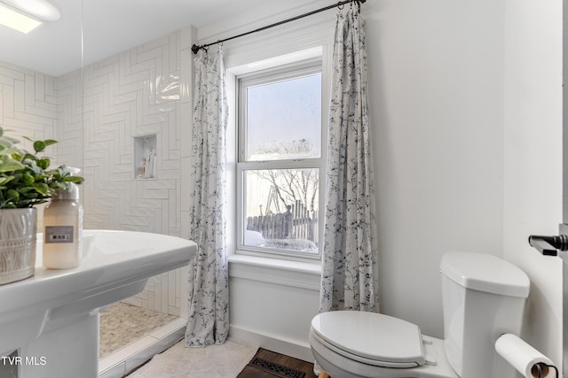 bathroom featuring toilet and baseboards