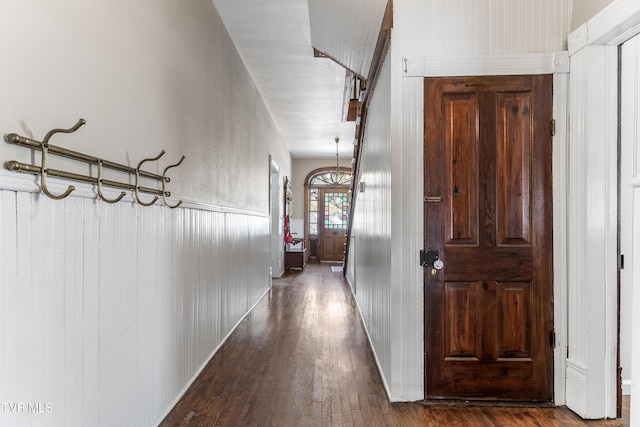 corridor featuring dark wood-style flooring and wainscoting