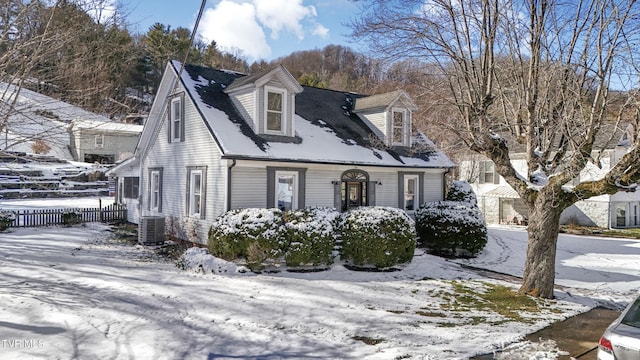 view of front of property with fence and central AC