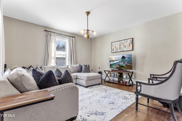 living area featuring a notable chandelier, baseboards, and wood finished floors