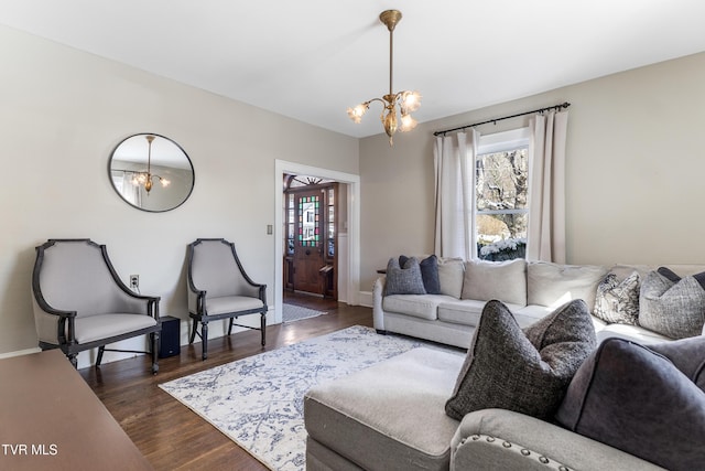 living room featuring dark wood finished floors, a notable chandelier, and baseboards