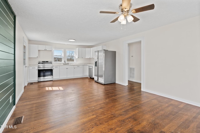 kitchen with dark wood-style flooring, visible vents, stainless steel appliances, and light countertops