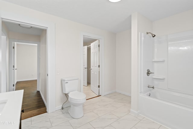 full bath with toilet, marble finish floor, baseboards, and shower / washtub combination