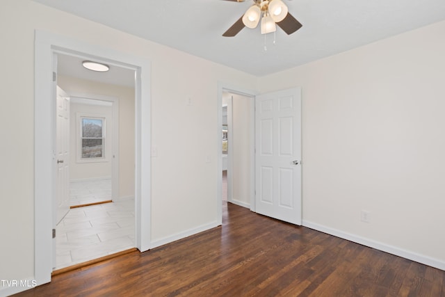 spare room with ceiling fan, baseboards, and wood finished floors