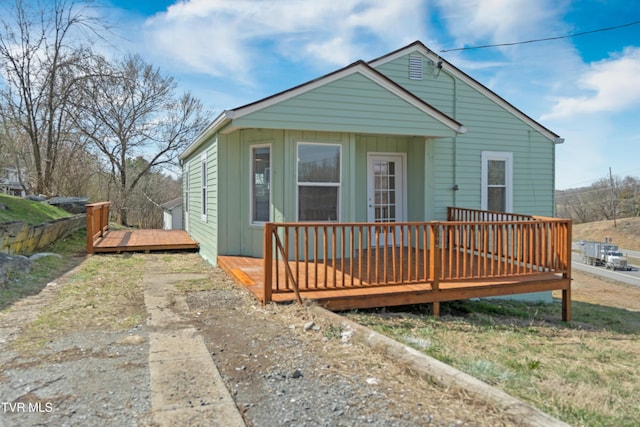 bungalow-style house featuring a deck and board and batten siding