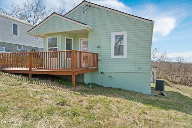 rear view of house with central AC unit, a lawn, and a wooden deck