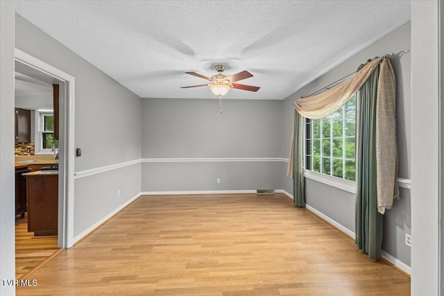 1016 Grace Dr, Johnson City, TN 37604 - unfurnished room with a ceiling fan, light wood finished floors, a textured ceiling, and baseboards