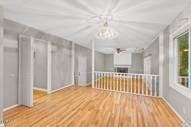 1016 Grace Dr, Johnson City, TN 37604 - spare room featuring a ceiling fan, wood finished floors, a chandelier, a fireplace, and baseboards