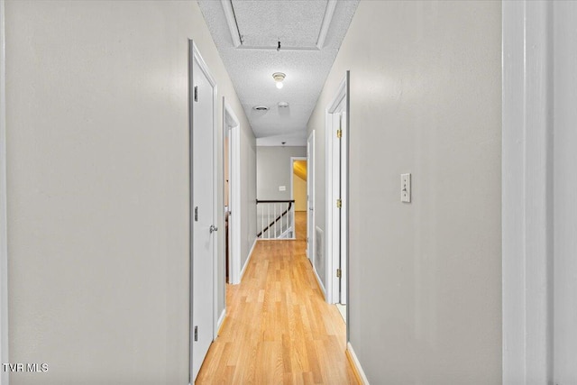 1016 Grace Dr, Johnson City, TN 37604 - hallway with an upstairs landing, light wood finished floors, a textured ceiling, and baseboards
