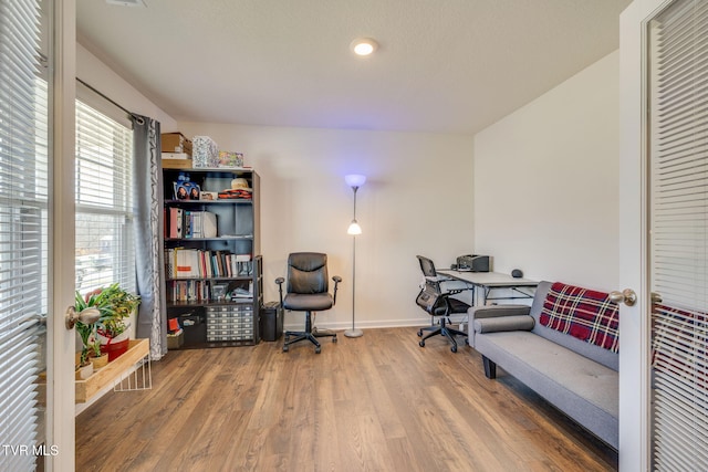 home office with baseboards and wood finished floors