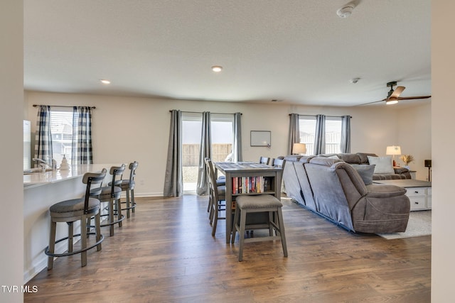 dining area with baseboards, dark wood finished floors, a ceiling fan, a textured ceiling, and recessed lighting