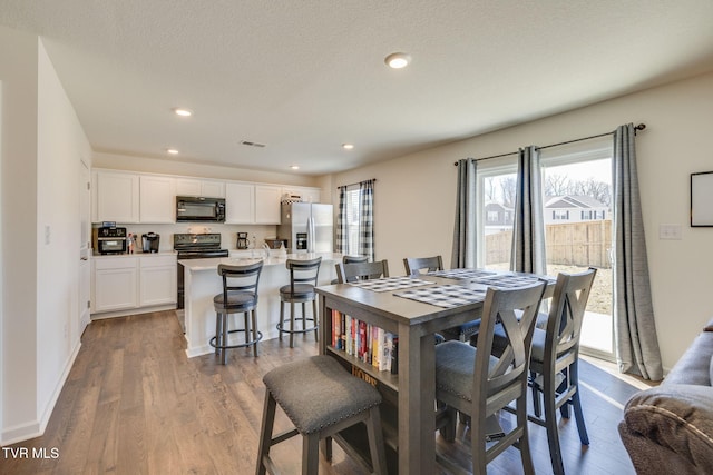 dining room with baseboards, dark wood-type flooring, visible vents, and recessed lighting