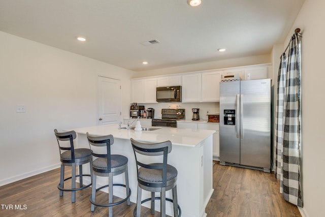 kitchen with black microwave, electric range, dark wood-type flooring, visible vents, and stainless steel refrigerator with ice dispenser