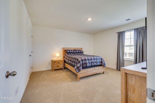 bedroom with light colored carpet, visible vents, baseboards, and a textured ceiling