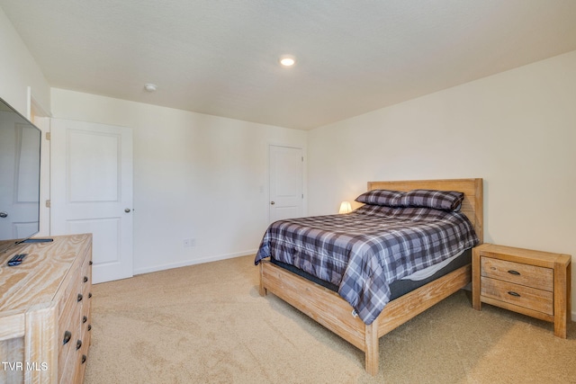 bedroom featuring light carpet and baseboards