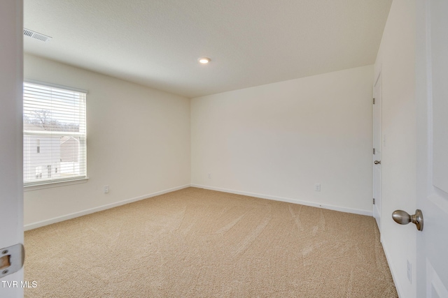 carpeted empty room featuring recessed lighting, visible vents, and baseboards