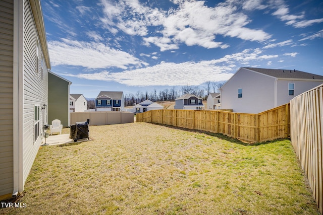 view of yard with a patio area, a fenced backyard, and a residential view