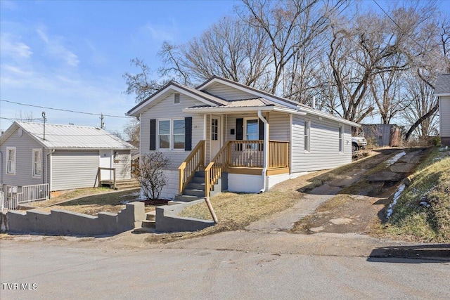 view of front of property featuring metal roof and driveway