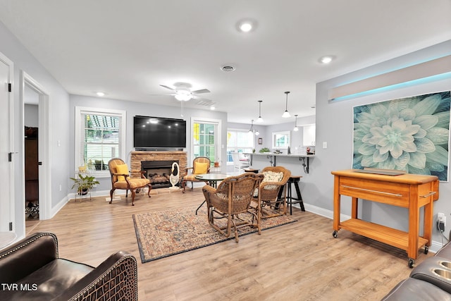 living room with a healthy amount of sunlight, visible vents, a fireplace, and light wood-style flooring