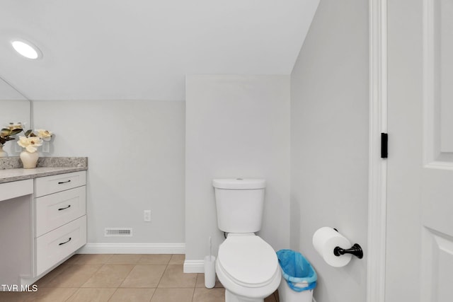 bathroom with toilet, visible vents, baseboards, vanity, and tile patterned floors