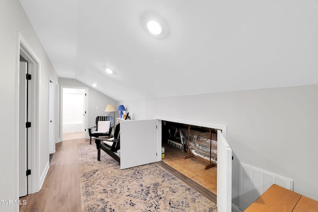 interior space with lofted ceiling, wood finished floors, visible vents, and recessed lighting