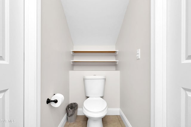 bathroom featuring toilet, tile patterned flooring, and baseboards