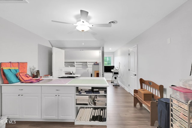 kitchen with dark wood-style floors, light countertops, visible vents, a ceiling fan, and white cabinetry