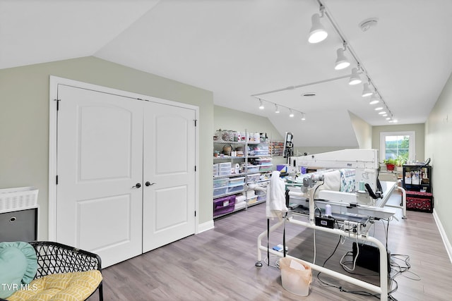 home office featuring lofted ceiling, light wood finished floors, and rail lighting