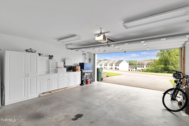 garage with a garage door opener and a residential view