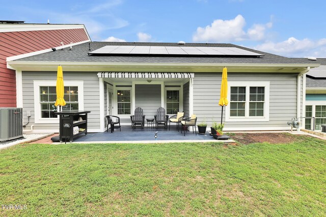 back of house with cooling unit, a patio area, and a lawn