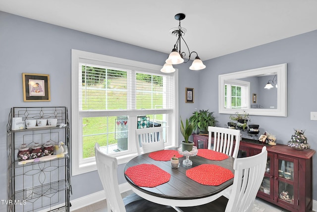 dining area with baseboards and a notable chandelier