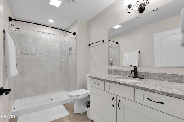 bathroom with toilet, a shower stall, tile patterned flooring, and vanity