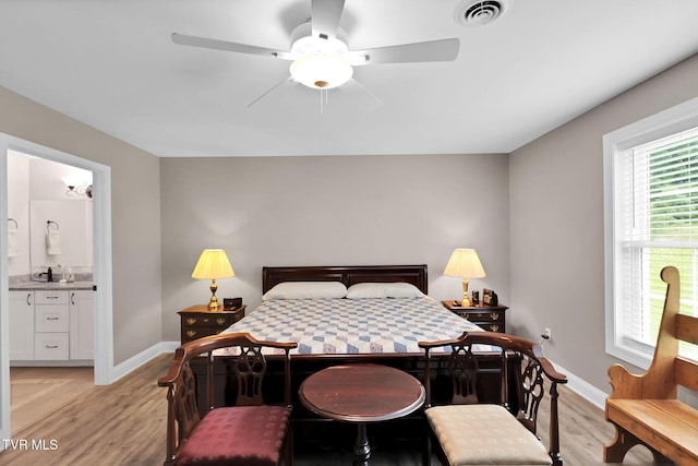 bedroom featuring light wood-style flooring, connected bathroom, visible vents, and baseboards