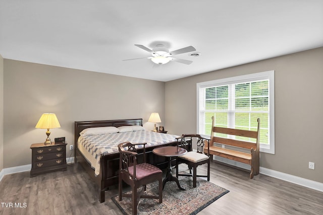 bedroom featuring baseboards, dark wood finished floors, and a ceiling fan