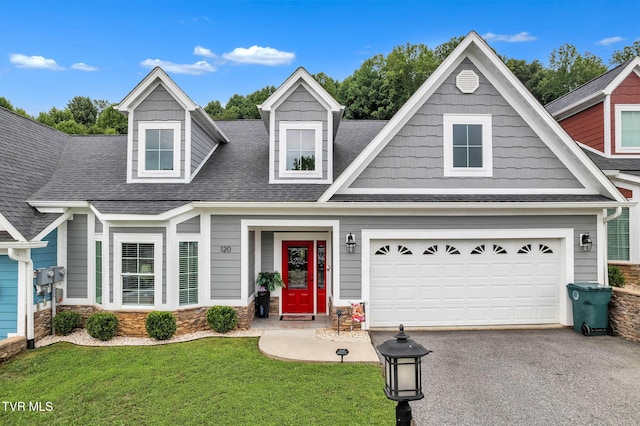 view of front of property featuring aphalt driveway, a front yard, roof with shingles, and a garage